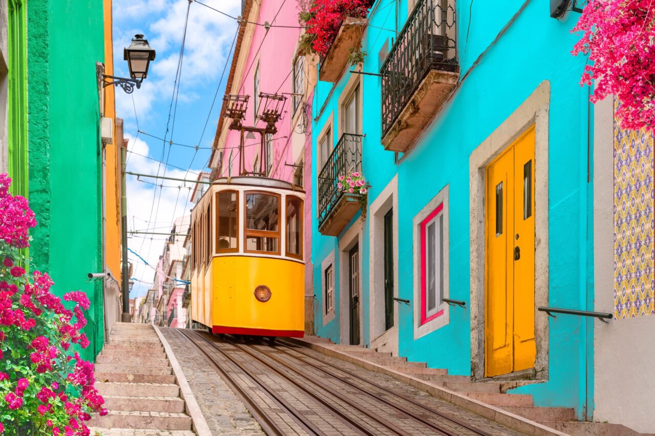 Iconic yellow tram in Lisbon, Portugal surrounded by colorful buildings